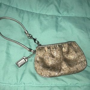 Brown Coach Wristlet with silver and gold logos